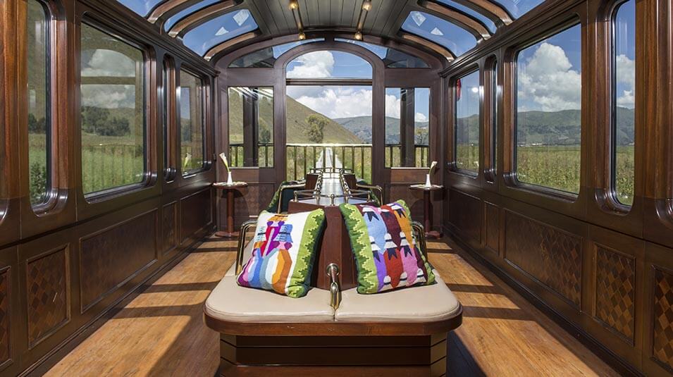 Interior del tren panorámico hacia Machu Picchu con ventanas amplias y vista a los Andes peruanos